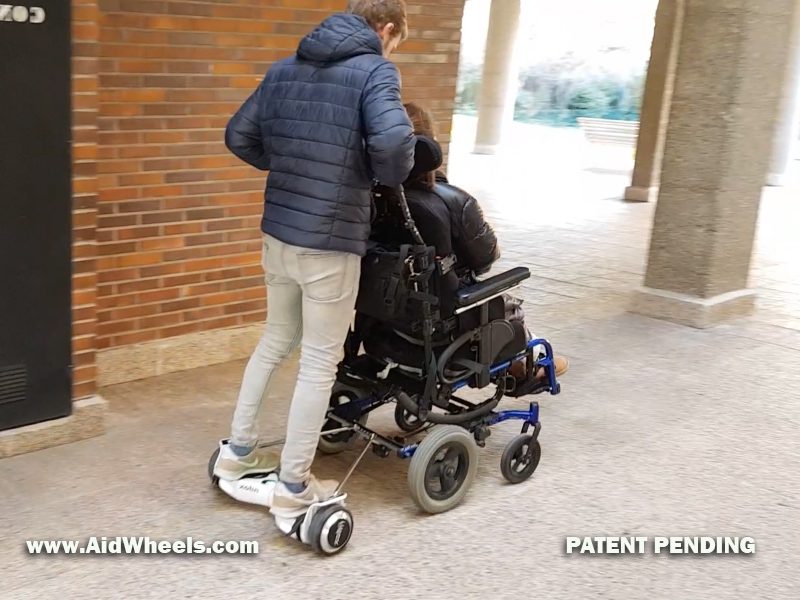 manejando una silla de ruedas con ayuda de un hoverboard y aidwheels adaptador